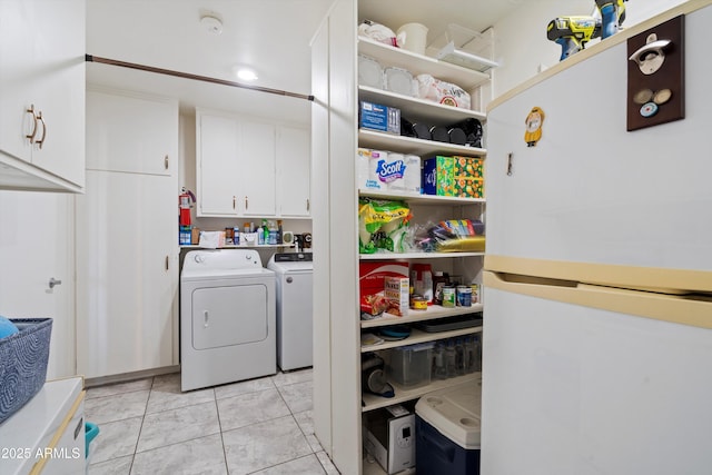 laundry area featuring cabinets, independent washer and dryer, and light tile patterned floors