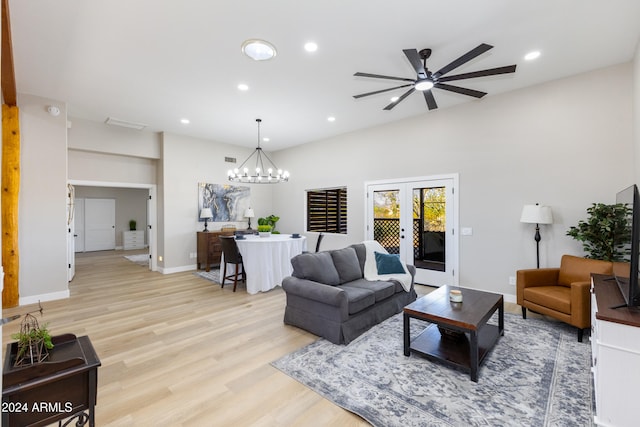 living room with light hardwood / wood-style flooring and ceiling fan with notable chandelier