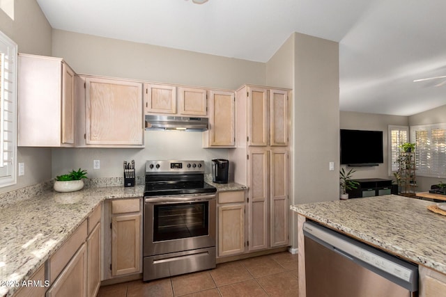 kitchen featuring light stone counters, lofted ceiling, light brown cabinetry, light tile patterned floors, and appliances with stainless steel finishes