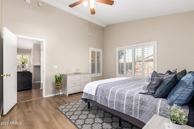 bedroom featuring multiple windows, ceiling fan, lofted ceiling, and hardwood / wood-style flooring