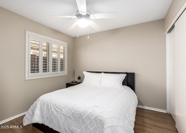 bedroom featuring ceiling fan, dark hardwood / wood-style flooring, and a closet