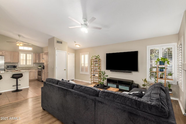 living room with vaulted ceiling, light hardwood / wood-style flooring, and ceiling fan