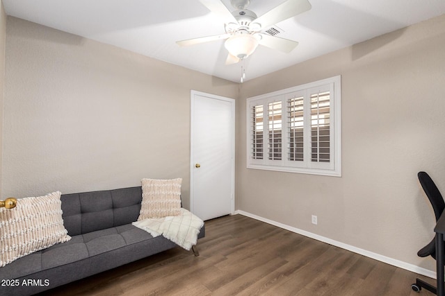 living area with ceiling fan and dark wood-type flooring