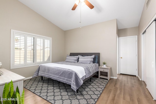 bedroom with ceiling fan, a closet, vaulted ceiling, and hardwood / wood-style flooring