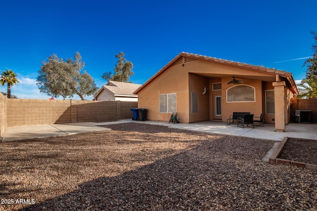 rear view of house featuring ceiling fan, cooling unit, and a patio area