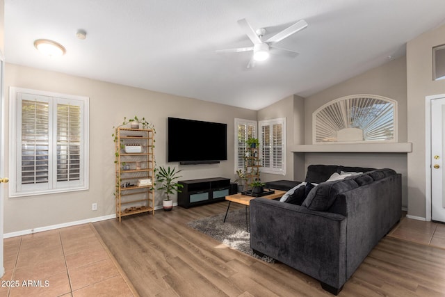 living room with ceiling fan, a healthy amount of sunlight, and lofted ceiling