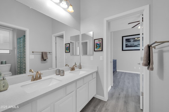 bathroom with hardwood / wood-style flooring, vanity, ceiling fan, and toilet