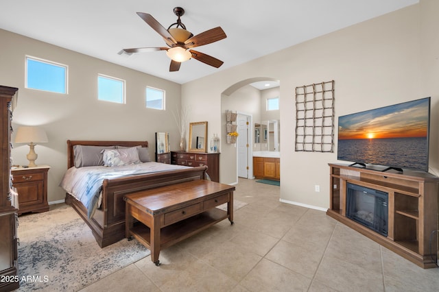 tiled bedroom featuring ensuite bath and ceiling fan