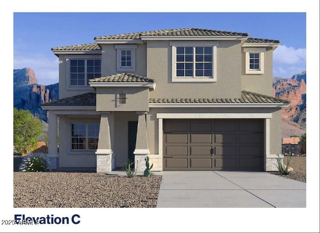 mediterranean / spanish home with concrete driveway, a garage, stucco siding, and a mountain view