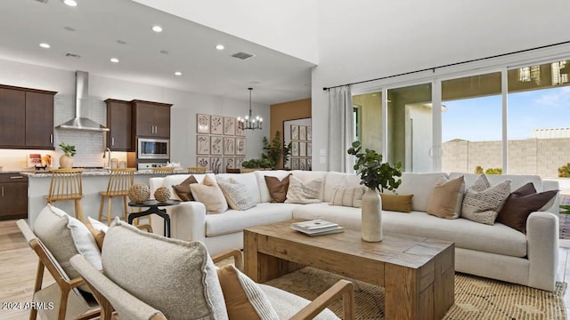living area featuring light wood-type flooring, a chandelier, visible vents, and recessed lighting