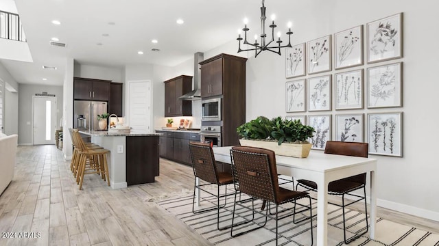 dining area featuring a notable chandelier, light wood-type flooring, visible vents, baseboards, and recessed lighting