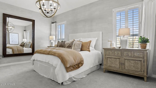 bedroom featuring light colored carpet, an inviting chandelier, and baseboards