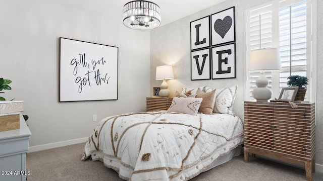 carpeted bedroom featuring a chandelier and baseboards