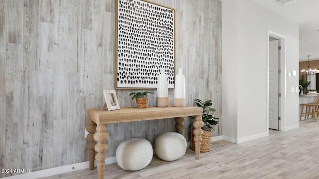 interior space with baseboards, an inviting chandelier, and wood finished floors