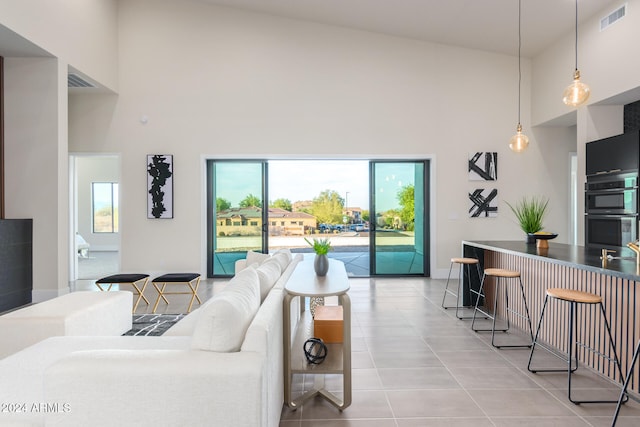 living room with high vaulted ceiling and tile patterned floors