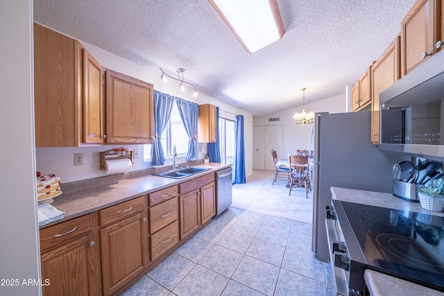 17810 N 34th Pl, Phoenix, AZ 85032 - kitchen featuring appliances with stainless steel finishes, a chandelier, lofted ceiling, a textured ceiling, and brown cabinets