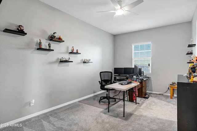 carpeted home office with ceiling fan and baseboards