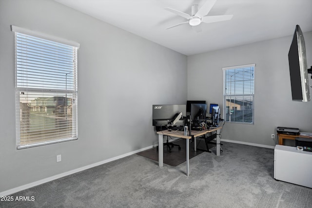 carpeted home office featuring a ceiling fan and baseboards