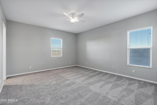 carpeted empty room with ceiling fan and baseboards