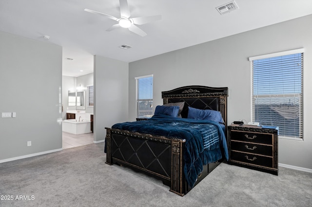 carpeted bedroom featuring visible vents, ensuite bath, and baseboards