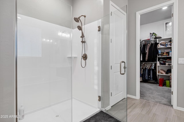 bathroom with a stall shower and a spacious closet