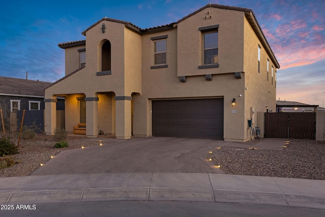 view of front of home with a tile roof, a gate, decorative driveway, and stucco siding