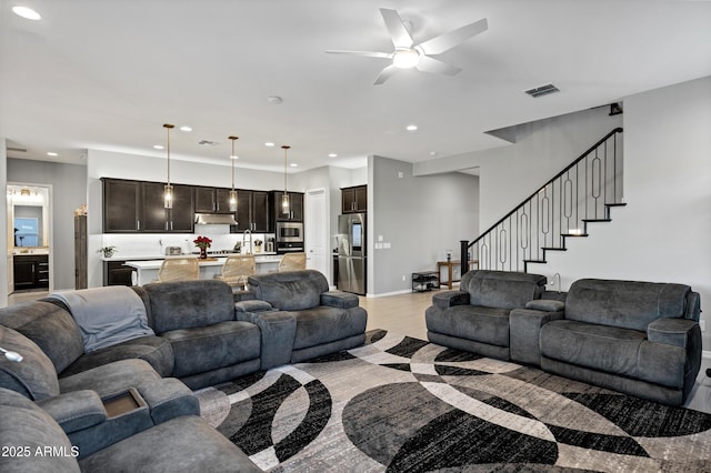 living room featuring recessed lighting, visible vents, light wood-style floors, baseboards, and stairs