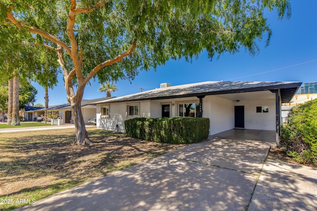 single story home featuring driveway, an attached carport, and stucco siding