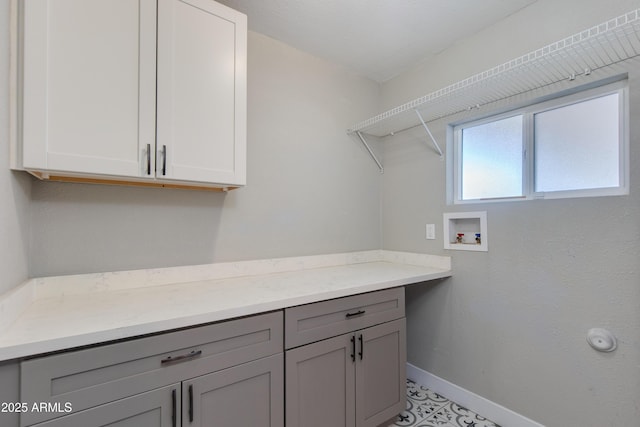 laundry room with cabinet space, hookup for a washing machine, and baseboards