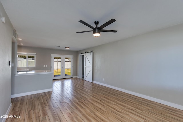 unfurnished living room with baseboards, ceiling fan, wood finished floors, and french doors