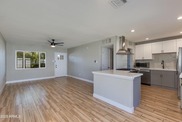 kitchen with visible vents, wall chimney exhaust hood, decorative backsplash, and appliances with stainless steel finishes