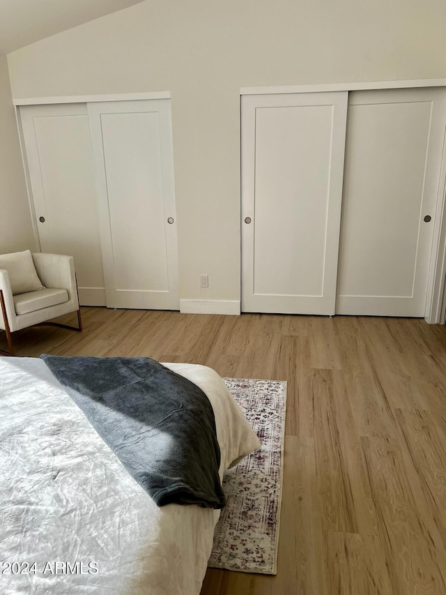 bedroom featuring light hardwood / wood-style flooring and vaulted ceiling