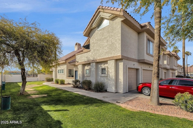 back of house with a garage and a yard