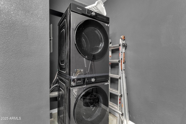 washroom featuring stacked washing maching and dryer