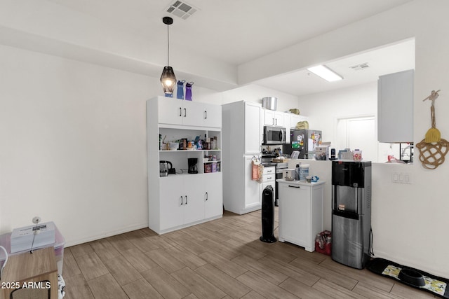 kitchen featuring white cabinetry, appliances with stainless steel finishes, and pendant lighting