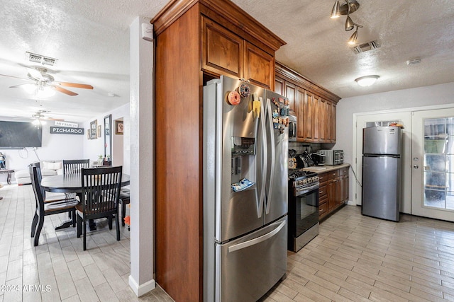 kitchen featuring a textured ceiling, stainless steel appliances, and ceiling fan