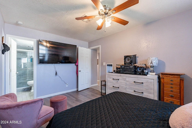 bedroom featuring connected bathroom, light hardwood / wood-style floors, a textured ceiling, and ceiling fan