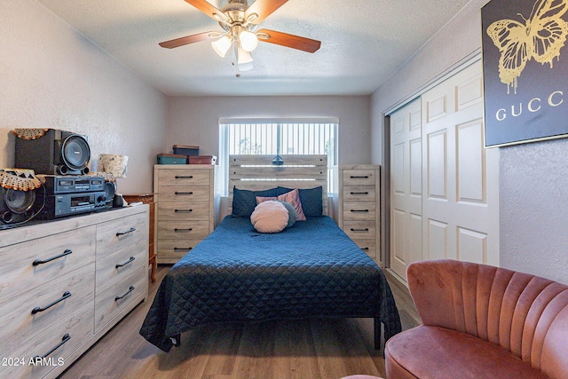 bedroom with hardwood / wood-style floors, a textured ceiling, a closet, and ceiling fan