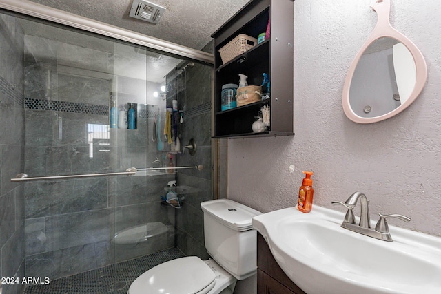 bathroom with vanity, toilet, walk in shower, and a textured ceiling