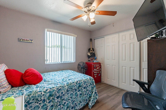 bedroom with light hardwood / wood-style flooring, a closet, and ceiling fan