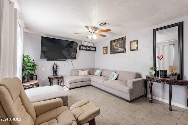 living room with ceiling fan and a textured ceiling