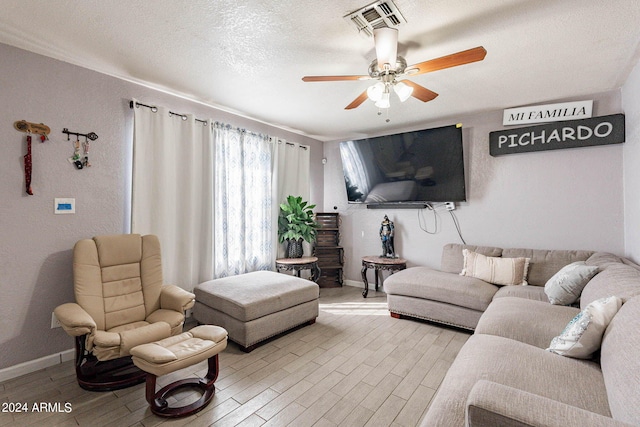 living room with light hardwood / wood-style floors, a textured ceiling, and ceiling fan