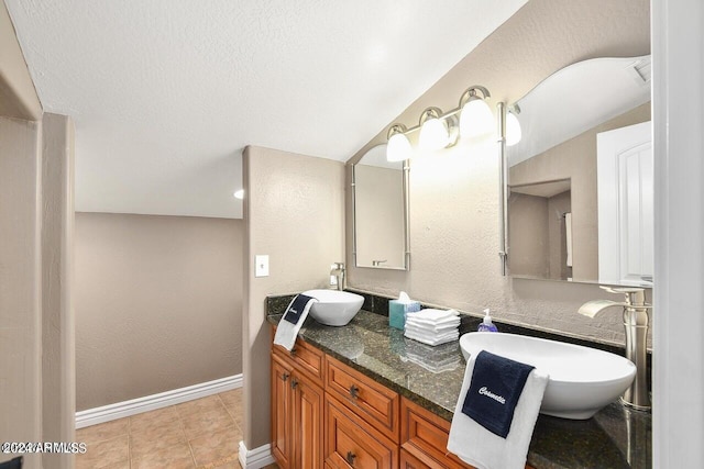 bathroom with lofted ceiling, vanity, and tile patterned floors