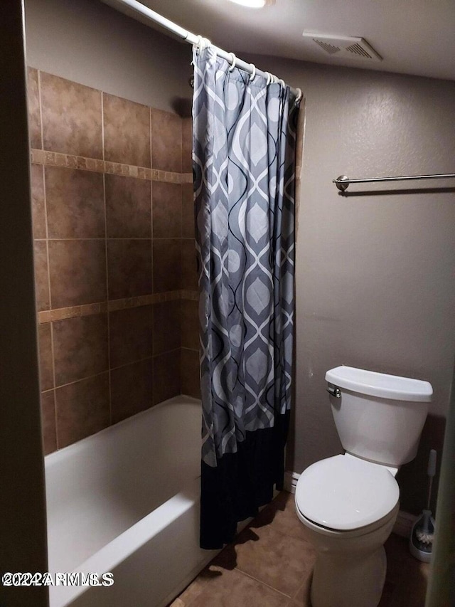 bathroom with shower / bath combo, toilet, and tile patterned floors