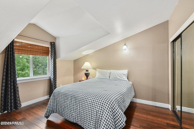 bedroom featuring a closet, dark hardwood / wood-style flooring, and lofted ceiling