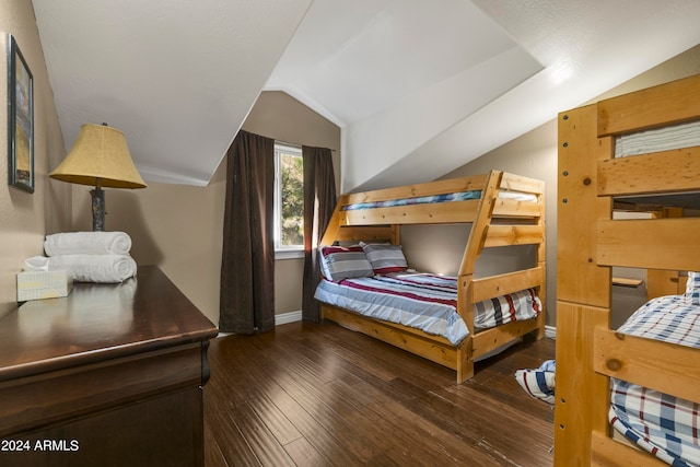 bedroom with vaulted ceiling and dark hardwood / wood-style floors