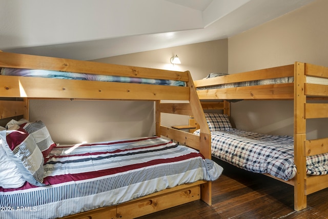 bedroom with vaulted ceiling and dark hardwood / wood-style floors