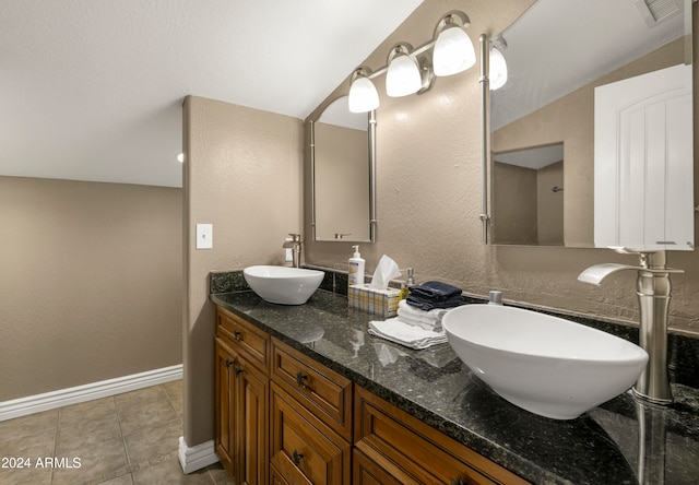 bathroom featuring vanity, lofted ceiling, and tile patterned floors