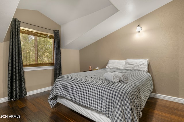 bedroom with vaulted ceiling and dark hardwood / wood-style flooring