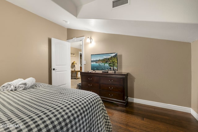 bedroom with lofted ceiling and dark hardwood / wood-style floors